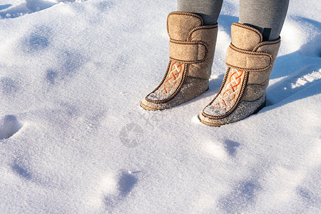 在雪中站立着 穿着脚靴的男人的近身羊毛村庄靴子鞋类季节晴天毛毡乡村雪堆图片
