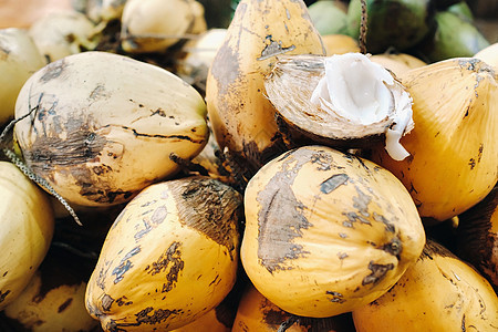 黄色椰子在毛里求斯岛的市场上出售 与 Makoto 一起切一个年轻的椰子 许多椰子在市场上坚果花园叶子热带异国食物牛奶健康情调蔬图片