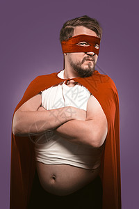 穿着披风和超级英雄服装的严肃男子被葡萄紫背景孤立了 权力概念 (注 “超人”是美国最有名的人物之一)图片