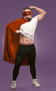 穿着红色超级英雄斗篷和面罩的勇士 在葡萄紫背景上站满身高 强势概念 (笑) 