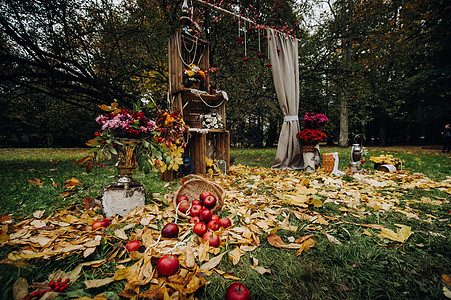 在绿草坪的街道上举行秋天婚礼 带有新鲜花拱门的朝圣仪式婚姻组织装饰安装背景金色天空报名草地文化背景图片