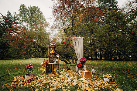在绿草坪的街道上举行秋天婚礼 带有新鲜花拱门的朝圣仪式风格文化奢华草地组织安装金色装饰天空森林图片
