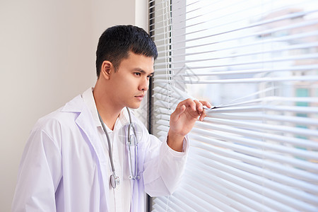 在医院从窗户窗外看的年轻男性年青男亚洲医生微笑药品卫生男人白色保健健康医疗图片