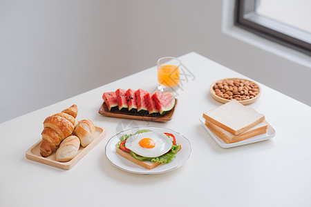 餐桌上美味的新鲜自制早餐面包西瓜沙拉盘子白色糕点美食桌子小吃午餐图片