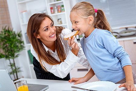 喂养女儿房子乐趣水平女孩微笑早餐用具食物厨房幸福背景图片