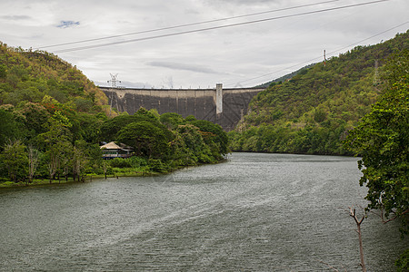 Tak 普密蓬大坝的正面图 是泰国第一座多用途水坝 用于农业和电力蓄水 弯曲的混凝土水坝流动活力水电蓝色场景水库涡轮技术发电机生图片