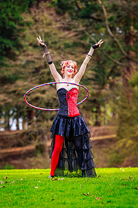 公园的Hula Hooop扮演草地树木呼啦圈戏服角色马戏团娱乐女性风景图片