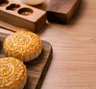 圆形新鲜出炉的月饼糕点中秋节的中国月饼在木制背景和服务托盘上特写美食甜点传统节日月亮桌子蛋糕乡村食物文化图片