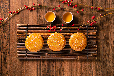 中国传统糕点月饼月饼与茶杯在竹制托盘上木制背景中秋节顶视图平躺美食杯子庆典节日服务蛋糕桌子植物茶碗文化图片