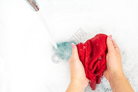 在水槽中用自来水洗彩色衣服的女子手肥皂盆地跑步泡沫清洁工服务棉布家务家庭衬衫图片