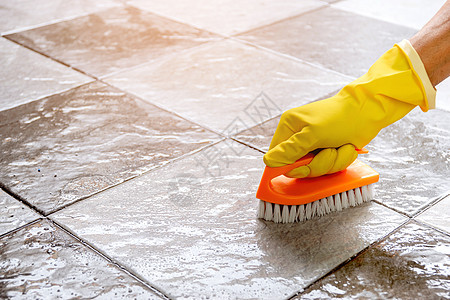 戴着黄色橡胶手套的手正用塑料地板刷用地板清洁剂擦洗瓷砖地板工具簸箕清洁工卫生灰尘海绵泡沫化学品刷子家务图片