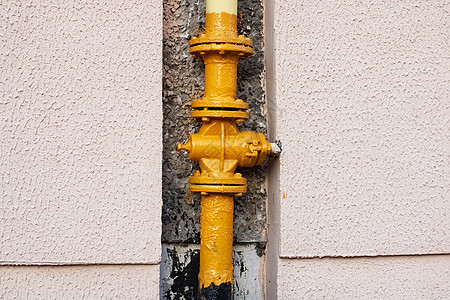 房屋墙上的黄色水管管子金属液体燃料气体压力房子力量螺栓活力图片