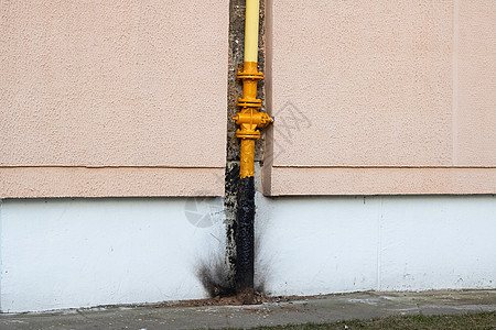 房屋墙上的黄色水管紧固件金属螺栓燃料力量工程气体技术阀门控制图片