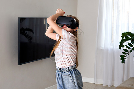 十几岁的女孩戴着虚拟现实护目镜耳机和 playingvr 盒 技术新一代进步理念 女孩试图触摸虚拟现实中的物体图片