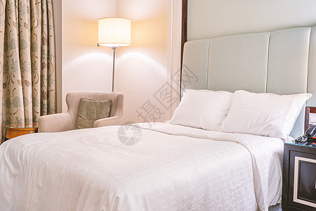 干净舒适的现代酒店卧室内饰 带立灯的暖色调房间 带垫子的亚麻沙发 豪华旅行的设计理念 特写软垫套房房子家具床单被子风格枕头假期床图片