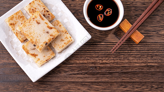 美味的萝卜蛋糕 中国传统红菜蛋糕 在餐厅里配有酱油做新年菜 特写 复制空间 顶层视野 平铺文化月球高架桌子筷子早餐美食大豆食物木图片