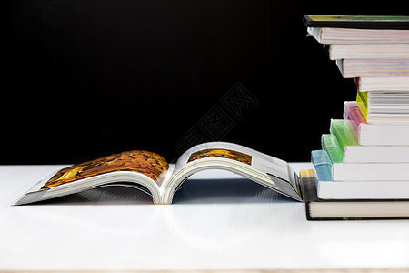 黑色背景的白桌上的堆叠书本大学蓝色科学知识智慧商业书店学习学校文档图片