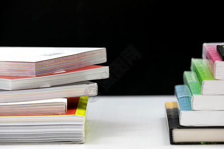 黑色背景的白桌上的堆叠书本书架科学图书馆教科书学习知识收藏大学文档学校图片