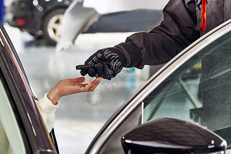 服务后向女性客户提供汽车钥匙的机械设备推销员代理人男人职业经销商司机女士商务钥匙手臂图片