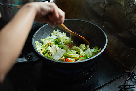 妇女在厨房煮炒菜 在厨房做饭图片