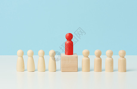 白色桌子上的木制小矮人 红色站在木制立方体上 寻找有才能的员工 造势 操纵群众 为团队选拔员工图片