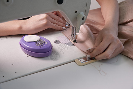 在现代美食店裁缝工作室使用缝纫机的妇女手指工人职业工艺爱好织物接缝制造业女裁缝衣服针线活高清图片素材