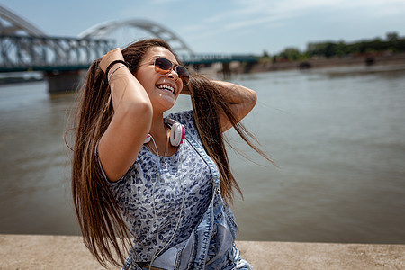 自由享受乐趣水平幸福微笑活动青少年女子耳机音乐头发河岸图片