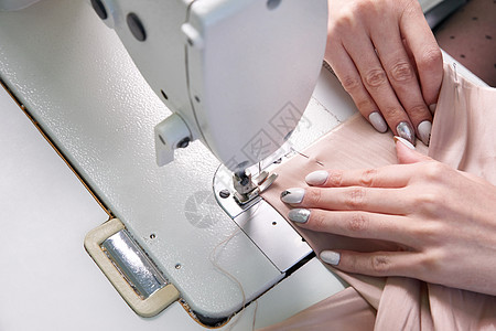 在现代美食店裁缝工作室使用缝纫机的妇女职业工作剪裁接缝设计师工厂作坊机器工人纺织品针线活高清图片素材