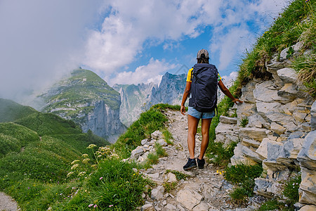 一个背着背包的女人站在山顶 这个女孩去美丽的地方旅行 到达目标 的山脊 瑞士的 Kreuzberge运动游客远足中年生活方式女性图片