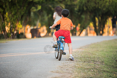 年轻亚洲男孩在路上骑自行车图片