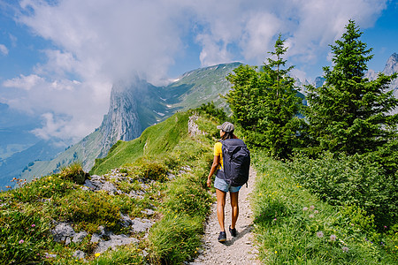 一个背着背包的女人站在山顶 这个女孩去美丽的地方旅行 到达目标 的山脊 瑞士的 Kreuzberge岩石游客自由悬崖旅游生活方式图片