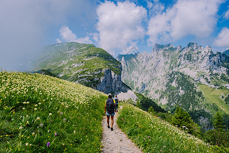 一个背着背包的女人站在山顶 这个女孩去美丽的地方旅行 到达目标 的山脊 瑞士的 Kreuzberge活动草地假期自由悬崖山脉女士图片