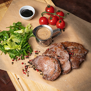 新鲜猪肉片配生菜沙拉 芝麻菜籽胡椒混合物和樱桃番茄 餐厅的概念 餐厅食物 烧烤理念图片