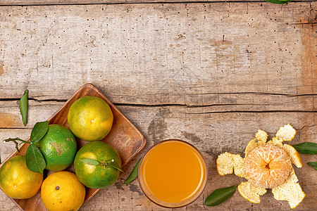在木制背景的玻璃杯里 新鲜剥皮橘子汁橘子饮料早餐饮食白色玻璃橙子热带食物黄色背景图片