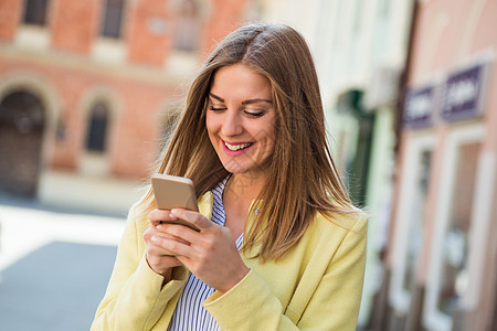 使用移动电话的妇女成人手机黄色城市生活金发女郎女性技术街道微笑城市图片