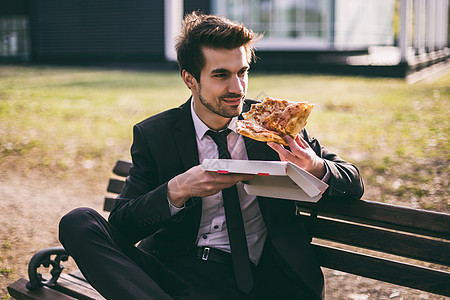外出吃披萨的商务人士午餐休息时间城市生活快乐白领阶层公园小吃男性职业男人休闲图片