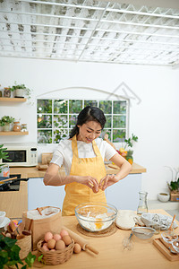 女人把鸡蛋碎成玻璃碗裂缝面包美食食物烹饪厨师蛋黄烘烤面粉面团图片