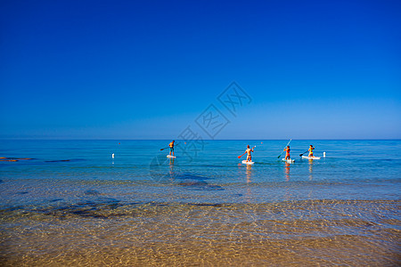 一群好友在海中训练SUP板子 在雷蒙海滩的阳光明媚的清晨上 罗蒙海滩运动锻炼乐趣冲浪者冒险旅行男生冲浪男人木板图片