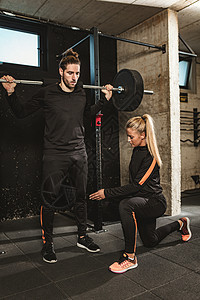 将自己推向极限运动培训师男人夫妻重量女士训练力量教练健身房图片