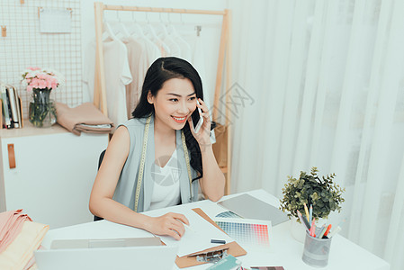 年轻亚洲创业妇女时装设计师在她家的阁楼工作草图作坊女裁缝工作室企业家材料女士幸福缝纫工艺图片