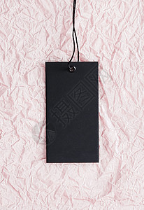 粉红纸背景 可持续时装和品牌标签概念上的黑色黑衣贴印牌图片