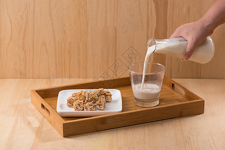奶制品 一瓶牛奶和一杯牛奶 在木制桌上配有杏仁糖玻璃营养早餐桌子厨房饮食食物水壶白色木头图片