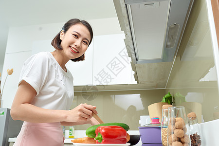 快乐的亚洲女人在厨房做饭平底锅烹饪女士围裙食物女性蔬菜食谱主妇早餐图片