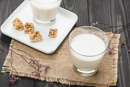 乳制品 质朴的木桌上放着一杯牛奶和杏仁糖白色桌子奶油饮料玻璃早餐酸奶饮食瓶子营养图片