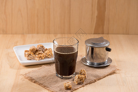 咖啡和杏仁糖放在木制桌上图片