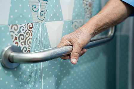 亚洲老年或老年老妇人病人在护理医院病房使用厕所浴室手柄安全 健康强大的医疗理念旅馆扶手栏杆合金洗澡残障老年人退休座位淋浴图片