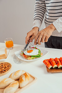 年轻人用刀和叉子吃早餐食物盘子美食午餐蛋黄男人烹饪面包绿色小吃图片