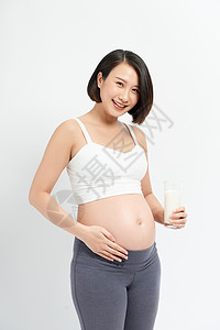孕妇在白色背景上喝着牛奶的女士女性腹部玻璃母亲婴儿父母母性生活肚子图片