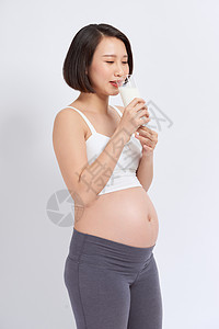 孕妇手里握着牛奶杯子 身体好 白种背景孤立无援母亲房间孩子女性腹部婴儿奶制品女士母性怀孕图片