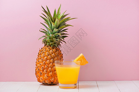 粉红背景上桌上的菠萝汁玻璃杯食物水果橙子黄色果汁粉色绿色玻璃饮料蓝色图片